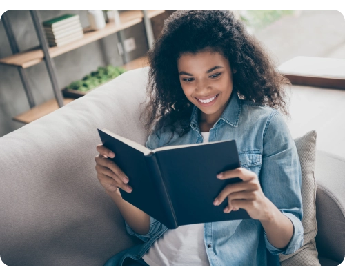 A woman reading and smiling because she found the user experience information she wanted from the userlytics blog posts